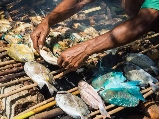 Photo of man hands grilling fresh fish