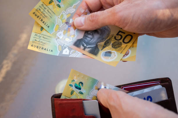 Hands holding wallet with australian dollars and make a payment - coronavirus finance struggle concept Hands holding wallet with australian dollars and make a payment - coronavirus finance struggle concept australian dollar stock pictures, royalty-free photos & images