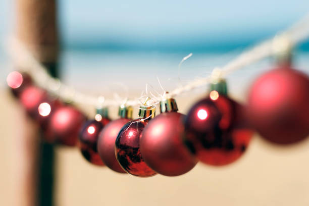 A garland of dark pink christmas baubles at the beach
