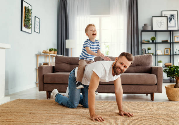 istock Father and little son having fun at home 1215409946