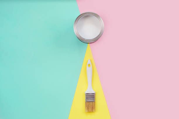 istock Open can with white paint and brush on color pastel background. 1215410893