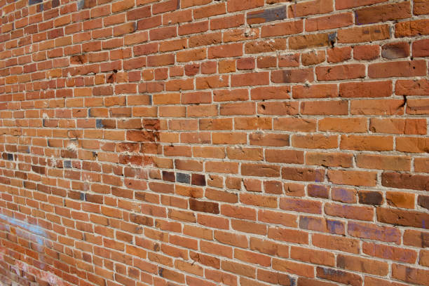 istock Old orange red clay brick wall with shabby chic deterioration 1215411043