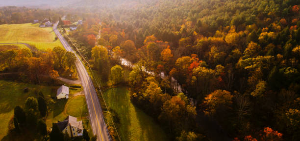 vue aérienne de la route de campagne dans la forêt dans la montagne dans le matin brumeux d’automne. - the poconos region photos et images de collection