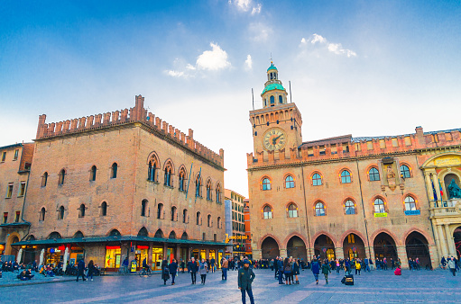 Bologna, Italy - March 10, 2023: Tourists on the Piazza Maggiore, medieval historical-architectural complex with the Palazzo d'Accursio and Palazzo dei Notai in Bologna, Italy