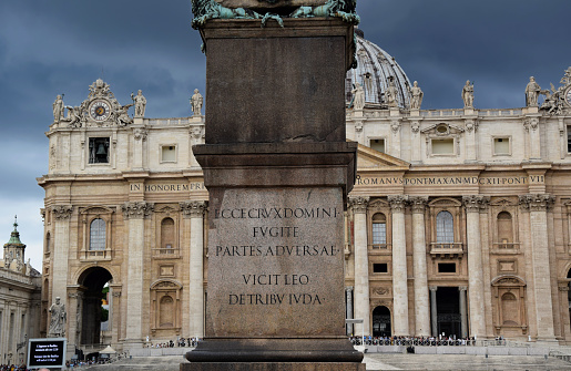 Vatican Obelisk, Maderno Fountain, Bernini´s Colonnade and Saint Peter´s Basilica on the Saint Peter´s Square in the city of Rome with people hustling araound or taking pictures