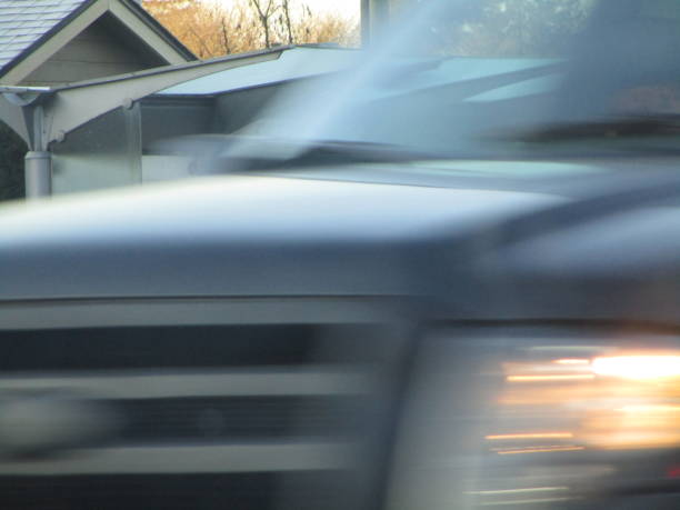 istock Black Car Driving Past Very Fast Close Up 1215418440
