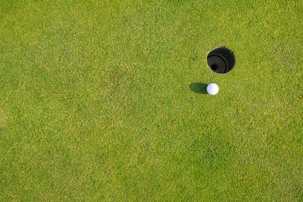 istock A golf ball near a cup on a golf course. 1215425510