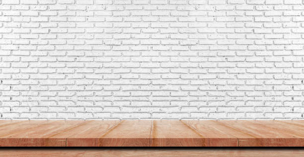 istock Empty wooden table top, counter or shelf on white brick wall background, For food display banner, backdrop. 1215430276