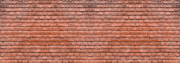 Dark brown old bricks wall panorama. Abstract brick texture for design or wallpaper.