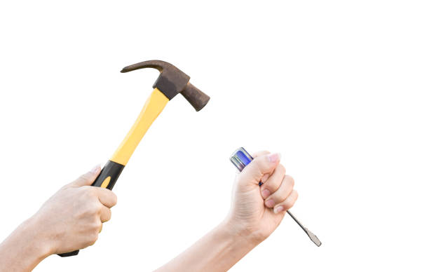 istock Male hands working with old rusty hammer and flat screwdriver isolated on white background with clipping path. 1215430324