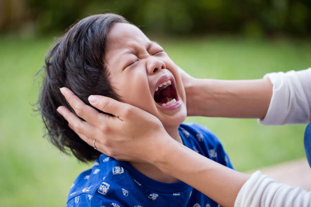 Little boy crying bitterly in the park stock photo