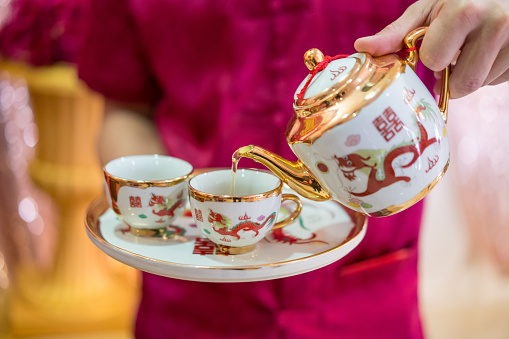 Man pouring tea into cups on Chinese traditional tea ceremony