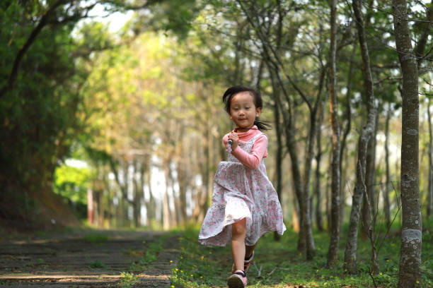istock a Asian girl running in a forest. 1215434468