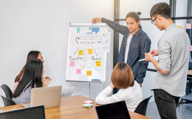 istock Young asian creative man leader standing and making presentation at modern office,asian people business meeting and brainstorm 1215436313