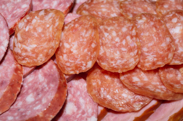 Salami background. many sliced pieces of sausage