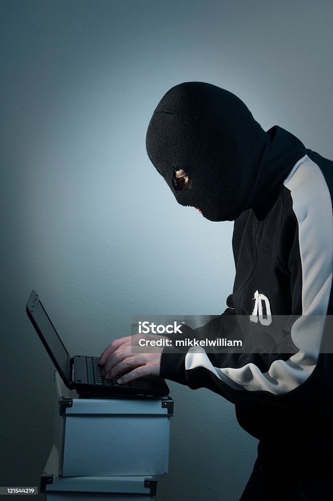 Hacker con maschera funziona su laptop interna - Foto stock royalty-free di Computer