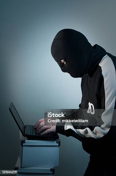 Foto de Hacker Com Máscara Performa No Laptop Coberta e mais fotos de stock de Computador - Computador, Dados, Roubando - Crime