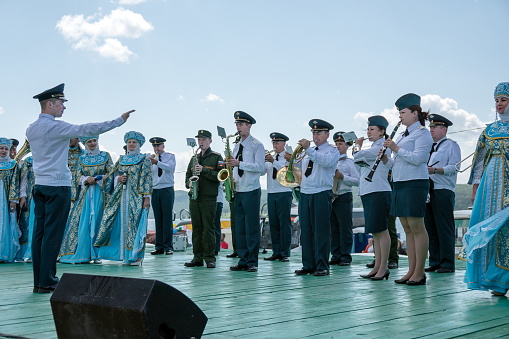 Parnaia, Sharypovskiy district, Krasnoyarsk region/ RF - 5 July 2019: A brass band of the Ministry of Internal Affairs and an ensemble in Russian folk costumes perform on the boardwalk, at the Karatag music festival.