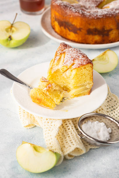 pièce de charlotte avec des pommes. délicieux gâteau aux pommes ou éponge décoré de sucre en poudre. éclairage atmosphérique matinal, ombres douces à la mode, mise au point sélective. - cake pie apple pie apple photos et images de collection