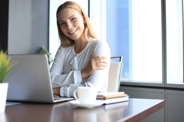 beautiful smiling business woman is sitting in the office and looking at camera - 4811 imagens e fotografias de stock