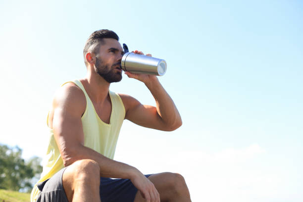 istock Athlete drinking water and relaxing after intense workout outdoors 1215450537