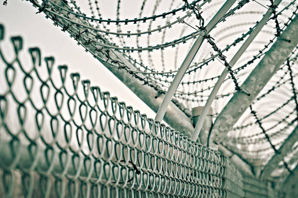istock border fence with barbed wire 1215452926