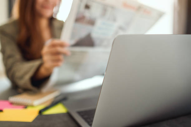 istock A business woman reading newspaper while working 1215454791