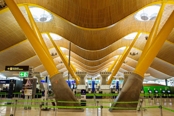 Airport control tower next to a terminal with fingers extended towards the planes