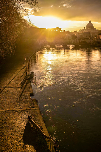 Rome, Italy -- A warm sunset over the golden waves of the Tiber river in the heart of the eternal city. Image in HD format.