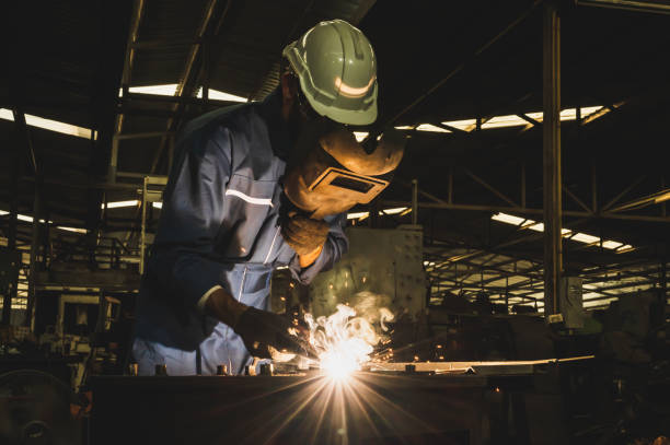 istock Industrial worker welding metal with many sharp sparks 1215456921