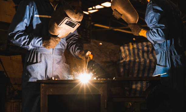 istock Industrial worker welding metal with many sharp sparks 1215457022