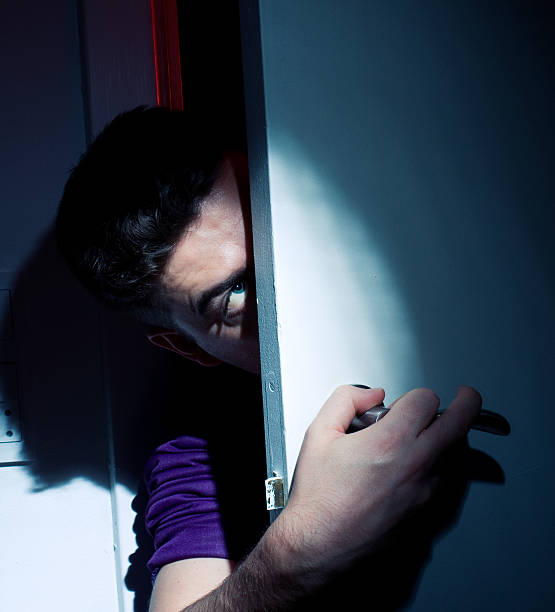 istock Scary man peeks through an open door at night 121545932