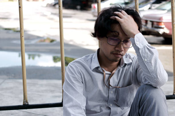 istock Tired and worried young Asian man suffering from severe depression 1215463503