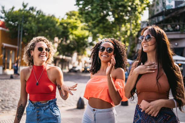 istock Three young women walking and laughing 1215464327