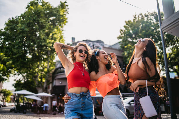 istock Three young women walking and laughing 1215464357