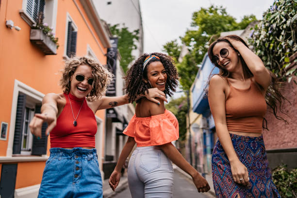 istock Three young women walking and dancing 1215464469