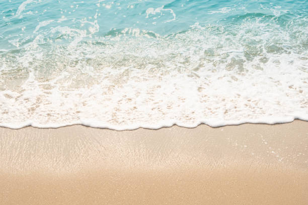istock wave of blue ocean on sandy beach. texture Background. 1215465553