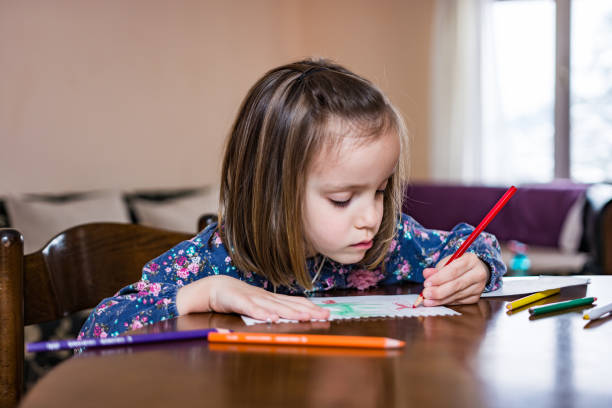 istock Little girl drawing at home 1215468637