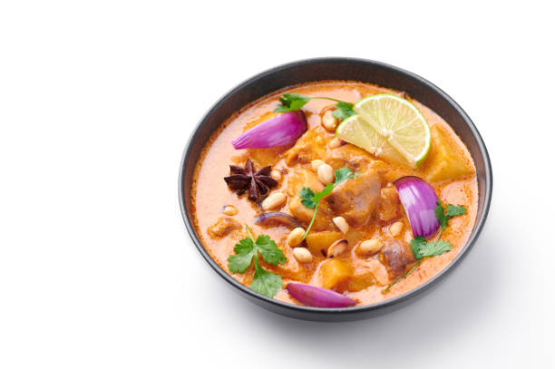 istock A Chicken Massaman Curry in black bowl isoated on white background. Massaman Curry is Thai Cuisine dish with chicken meat, potato, onion and many spices. Thai Food. Isolate 1215468761
