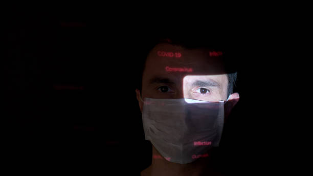 istock Projection of COVID-19 related text on a man's face 1215470093