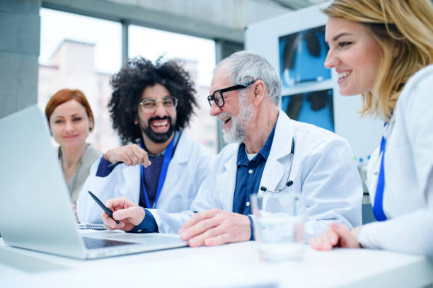 istock Group of doctors with laptop on conference, medical team discussing issues. 1215472045
