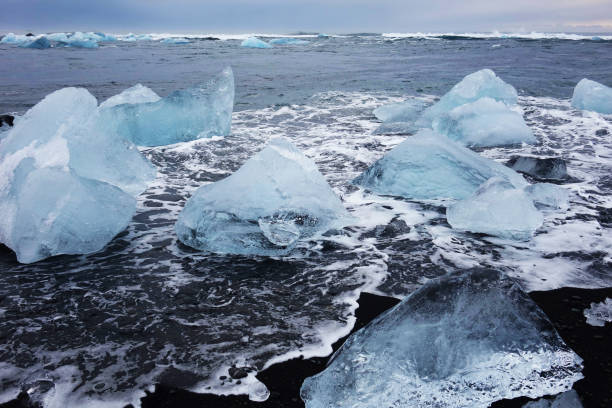 istock Black sandy beach with icebergs 1215472752