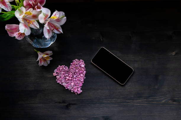 istock Happy Valentines day smart phone display. Table cloth on wooden background. 1215474075