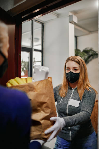 volunteer delivering food to elderly people during lockdown - volunteer senior adult teenager occupation imagens e fotografias de stock