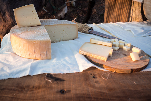Matured cheese on table and wooden cutting board.