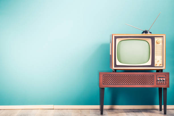 receptor de televisión clásico retro anticuado con antena de tv de alrededor de los años 60 del siglo xx en soporte de madera con fondo de pared azul menta degradado frontal amplificador. foto filtrada estilo vintage - retro look fotografías e imágenes de stock