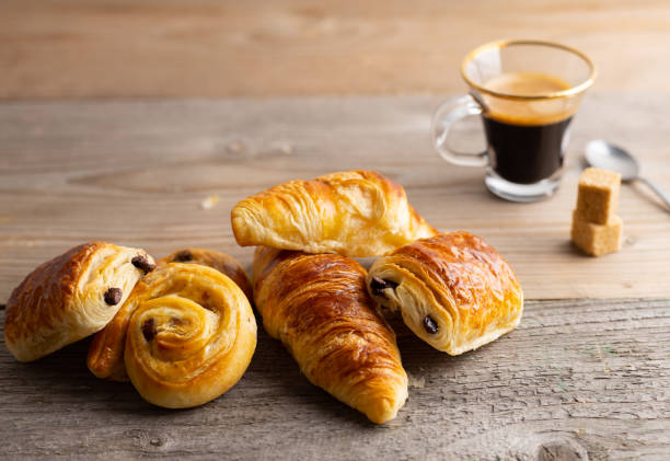 istock Breakfast table with croissants and cinnamon buns with fresh orange juice. 1215480361