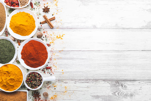 istock Various spices in a bowls on white wooden background. Top view with copy space. Cooking ingredients and condiments concept. 1215483334