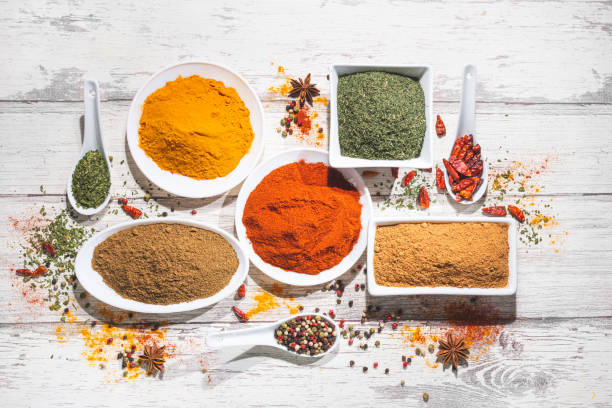 istock Various spices in a bowls on white wooden background. Top view with copy space. Cooking ingredients and condiments concept. 1215483353