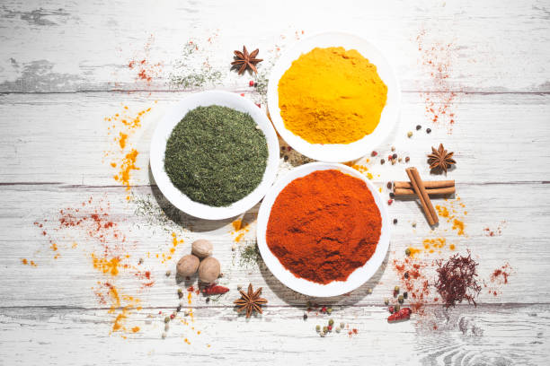 istock Various spices in a bowls on white wooden background. Top view with copy space. Cooking ingredients and condiments concept. 1215483358